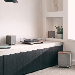 Ruark Audio RS1 Subwoofer Activo walnut vista de ambiente con un tocadiscos y unos altavoces Ruark