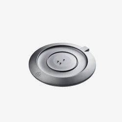 Devialet Mania, base de carga redonda vista de tres cuartos con los contactos y el logotipo D en el borde