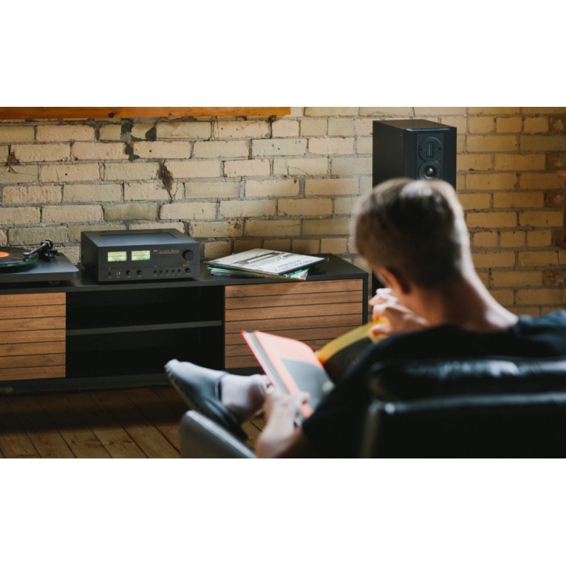 NAD C 3030 — el amplificador en un salón junto a una pared de ladrillo visto