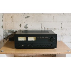 NAD C 3030 — sobre un mueble de madera con los vúmetros en primer plano