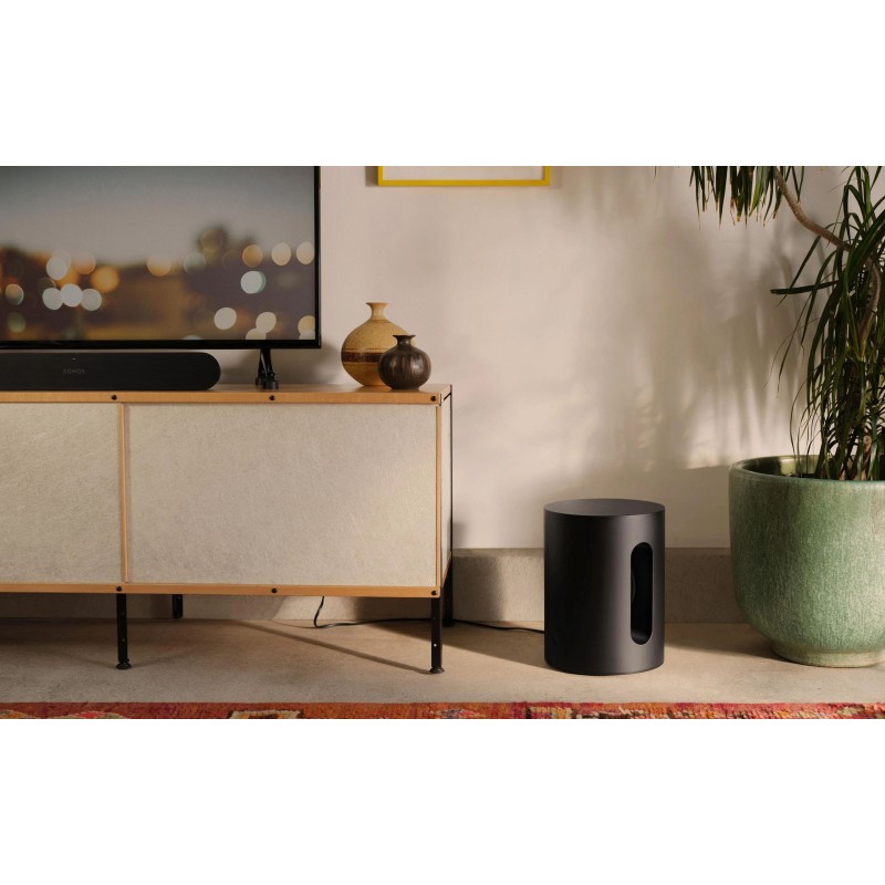 Sonos Bundle Beam Mini en negro, el Sub Mini en el suelo junto a un mueble bajo con una barra de sonido bajo el televisor