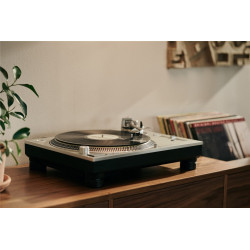 Cápsula Ortofon MC Cadenza en un tocadiscos, con discos de vinilo detrás