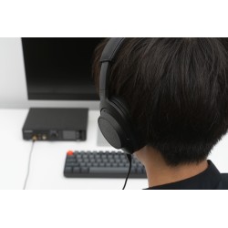 Final UX5000, auriculares de diadema en la cabeza de un adolescente, detalle del cable y un auricular