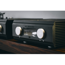 Musical Fidelity Nu-Vista PRE, negro en ángulo, en un mueble junto a un giradiscos