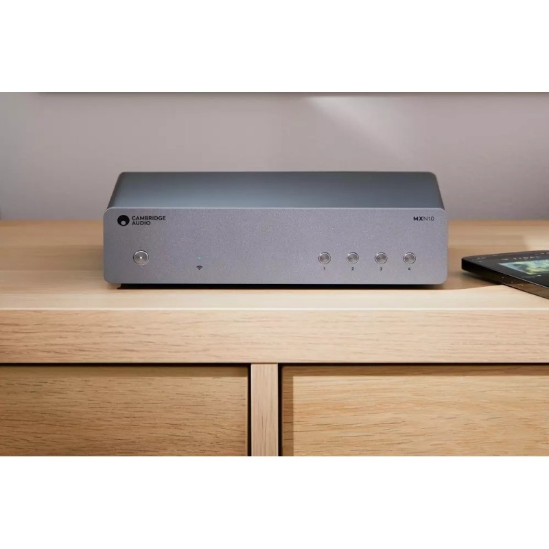 Cambridge Audio MXN10 + DacMagic 200M, el MXN10 sobre un mueble de madera clara junto a un móvil