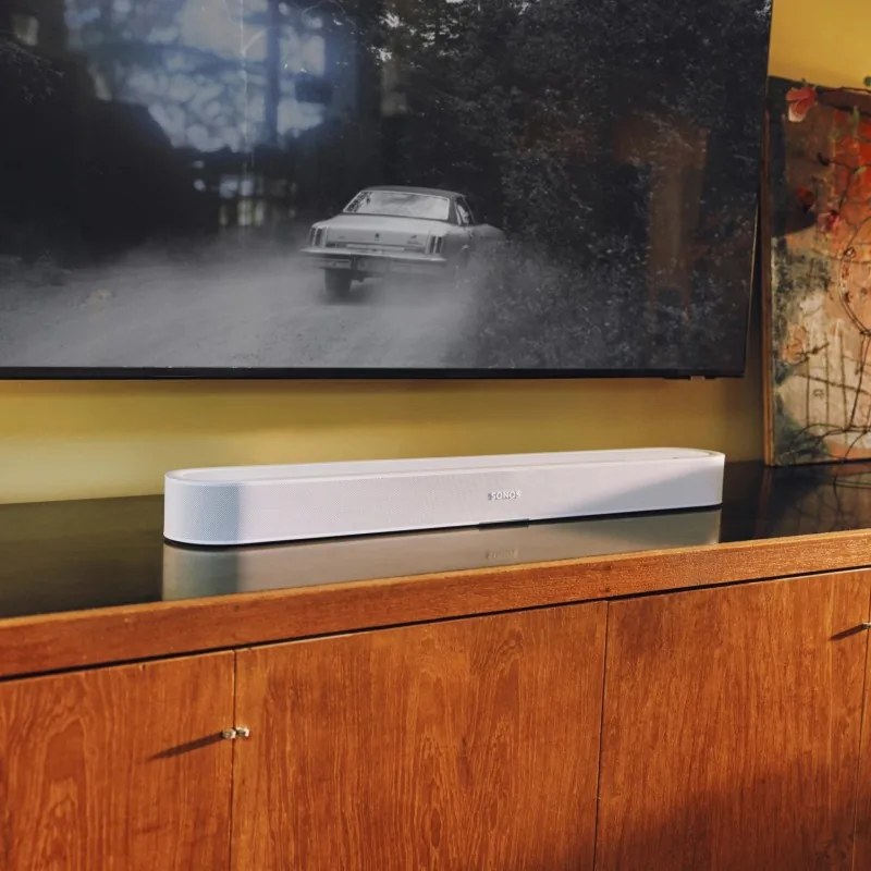 Sonos Beam Ultra bajo el televisor, en un mueble de salón